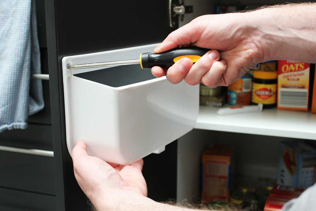 Screw the Trend Lid Tidy by HomeLeisure into the inside of a cupboard or pantry door.