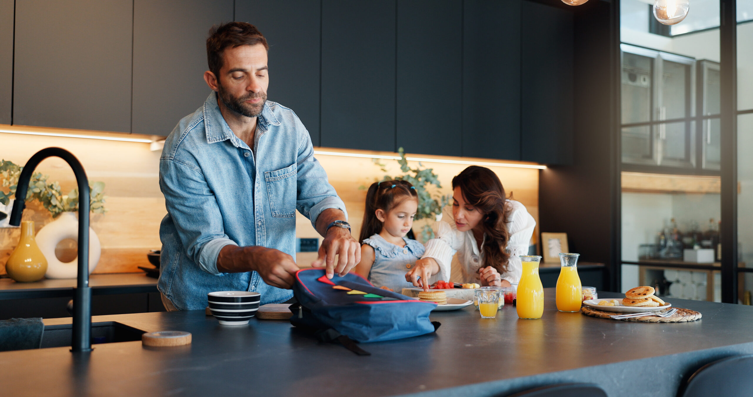 Parents, child and pack lunch in kitchen with healthy breakfast, getting ready and back to school. Mother, father and girl with family meal, nutrition food and prepare for kindergarten snack at house back to school