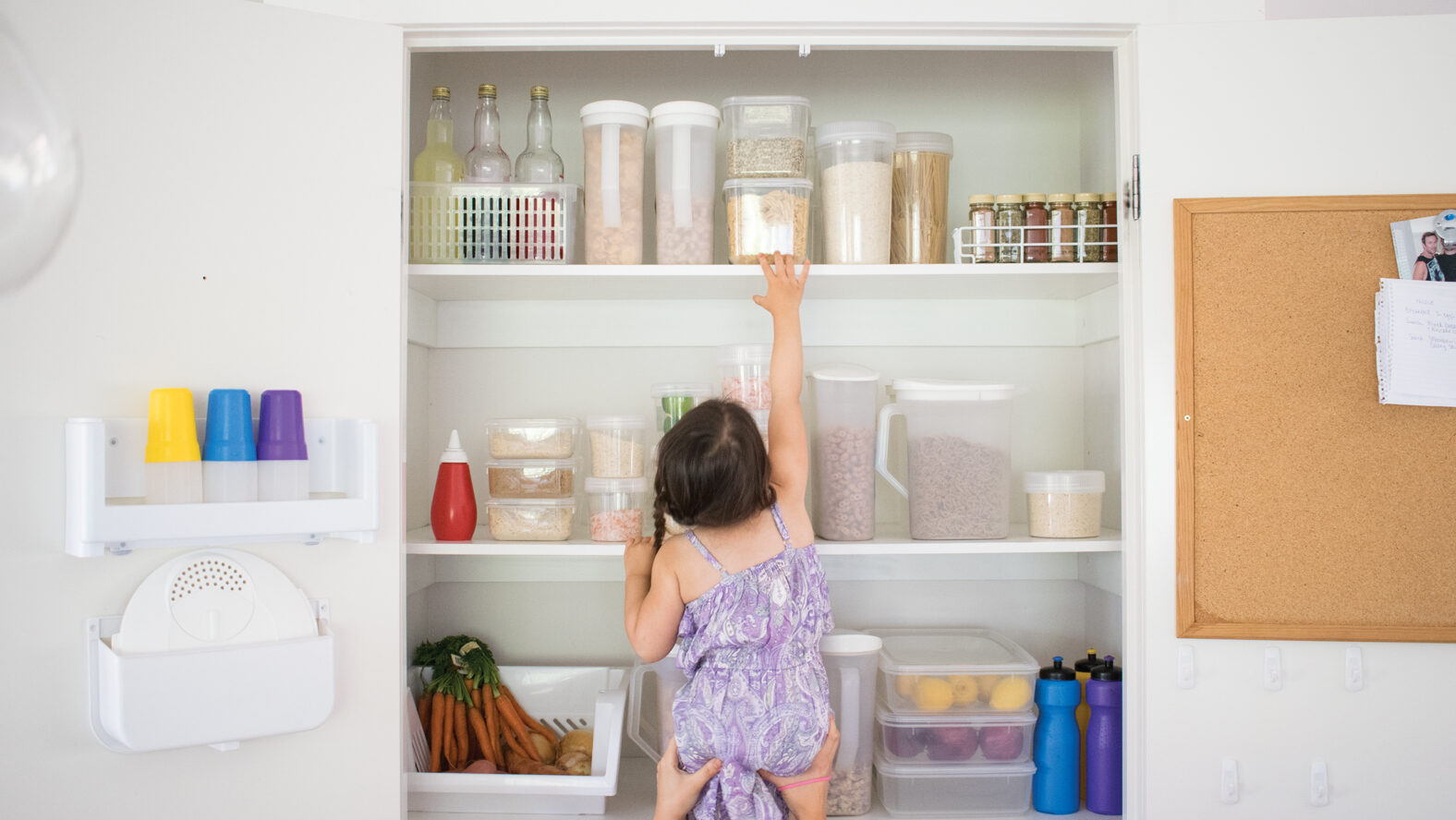 DSC_0171 a tidy pantry, stacked containers, and a child reaching for a container